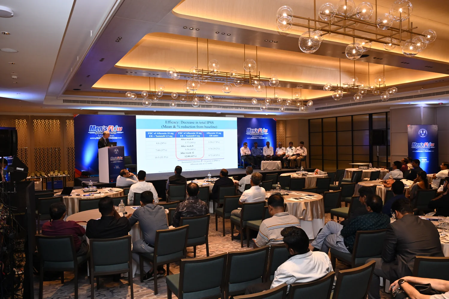 Delegates at a corporate conference in a warmly lit ballroom